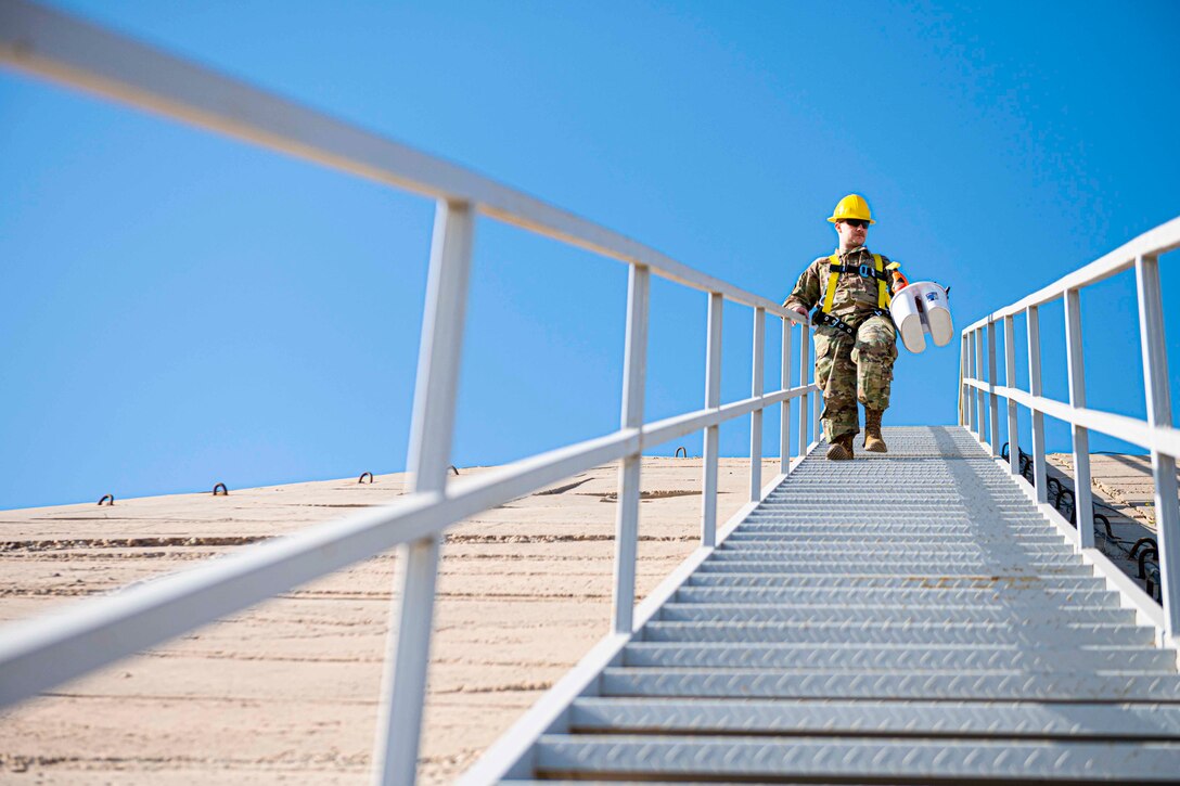 An airman walks down stairs.