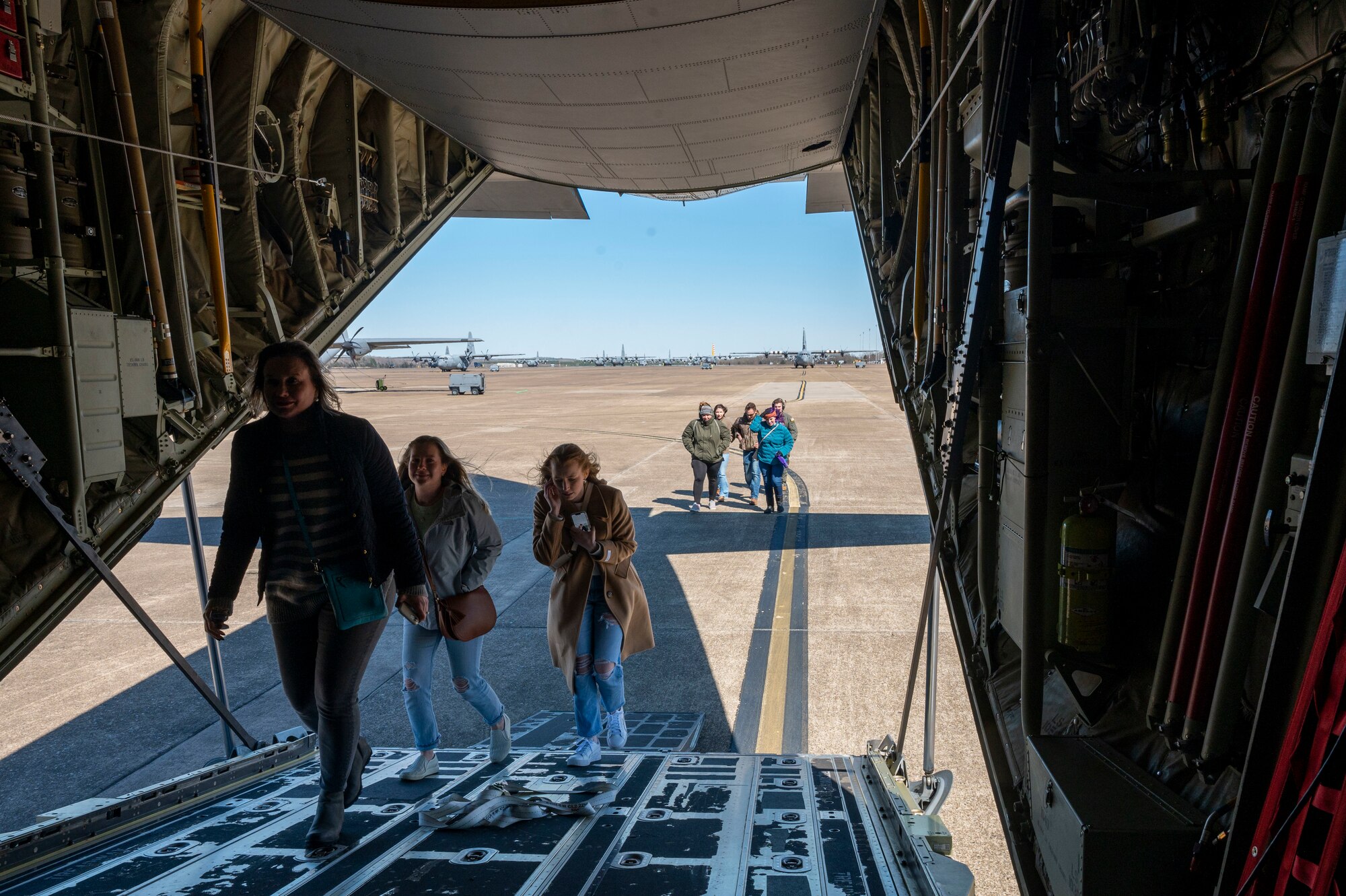 A group of people board a C-130J Super Hercules