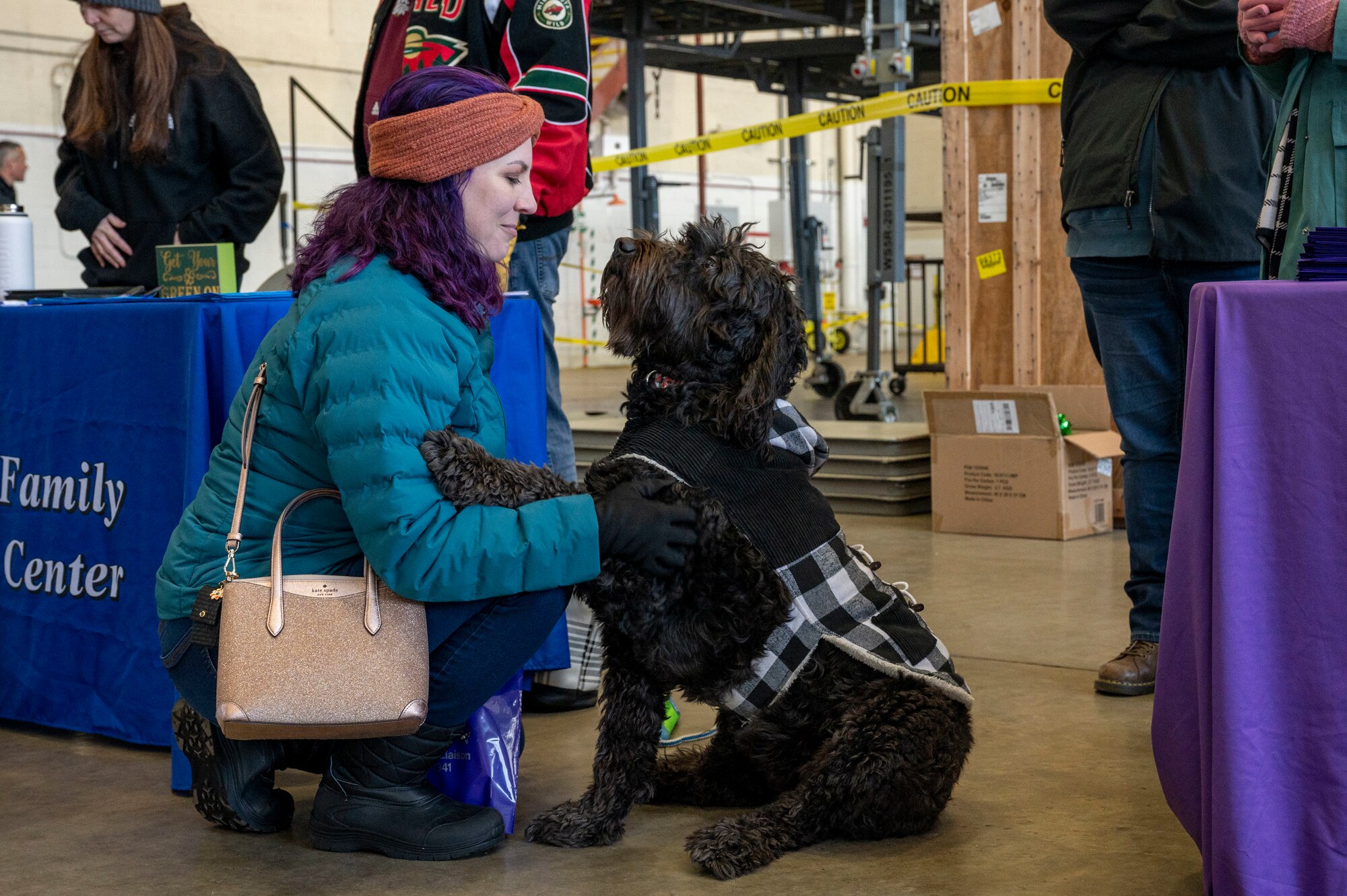 A service member’s family member pets a service dog