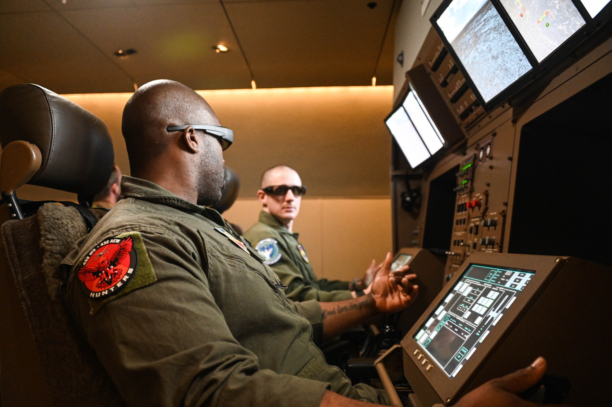 U.S. Air Force Tech. Sgt. Marcus (left), 432nd Air Expeditionary Wing evaluator sensor operator, talks with Master Sgt. Joseph Vondohlen, 54th Air Refueling Squadron boom operator instructor, in a Boom Operator Training (BOT) simulator at Altus Air Force Base, Oklahoma, March 9, 2022. BOT is almost an exact replica of the boom operator station in the KC-46 Pegasus. (U.S. Air Force photo by Senior Airman Kayla Christenson)