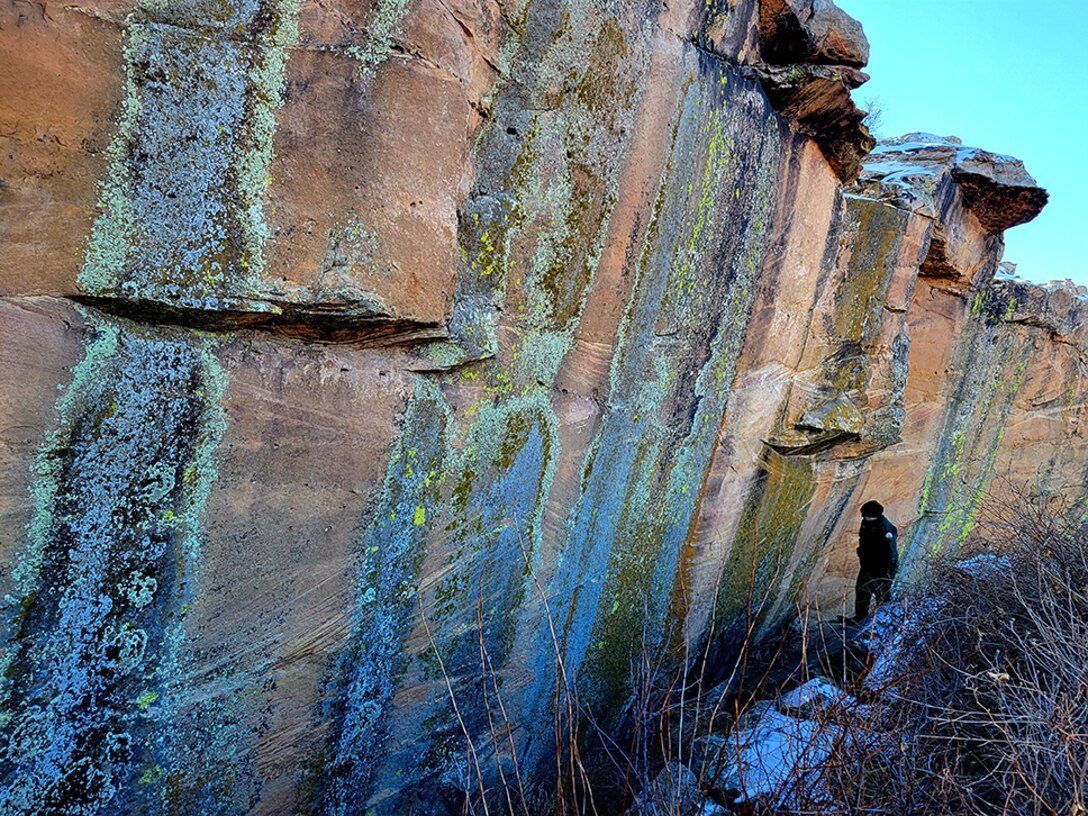 JOHN MARTIN RESERVOIR, Colo. -- A USACE park ranger searches a rock face near Hicklin Springs for hidden petroglyphs, Jan. 28, 2022. Photo by Holly Garnett, park ranger, John Martin Reservoir.