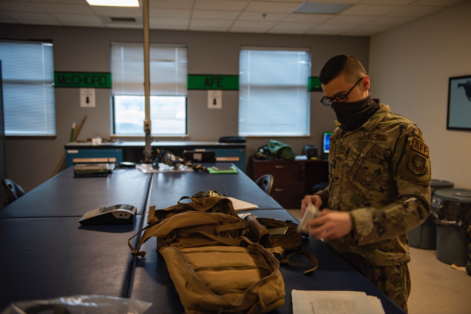 U.S. Air Force Senior Airman Connor O’Hare, 62nd Operations Support Squadron, aircrew flight equipment journeyman, completes a survival component upgrade to a new aircrew survival backpack at Joint Base Lewis-McChord, Wash., Feb. 18, 2022. The components in the survival backpacks are vital in providing downed personnel with essential life-sustaining items and rescue aids. The containers are designed to accommodate a maximum number of survival items in the least possible space. (U.S. Air Force photo by Tech. Sgt. Benjamin Sutton)