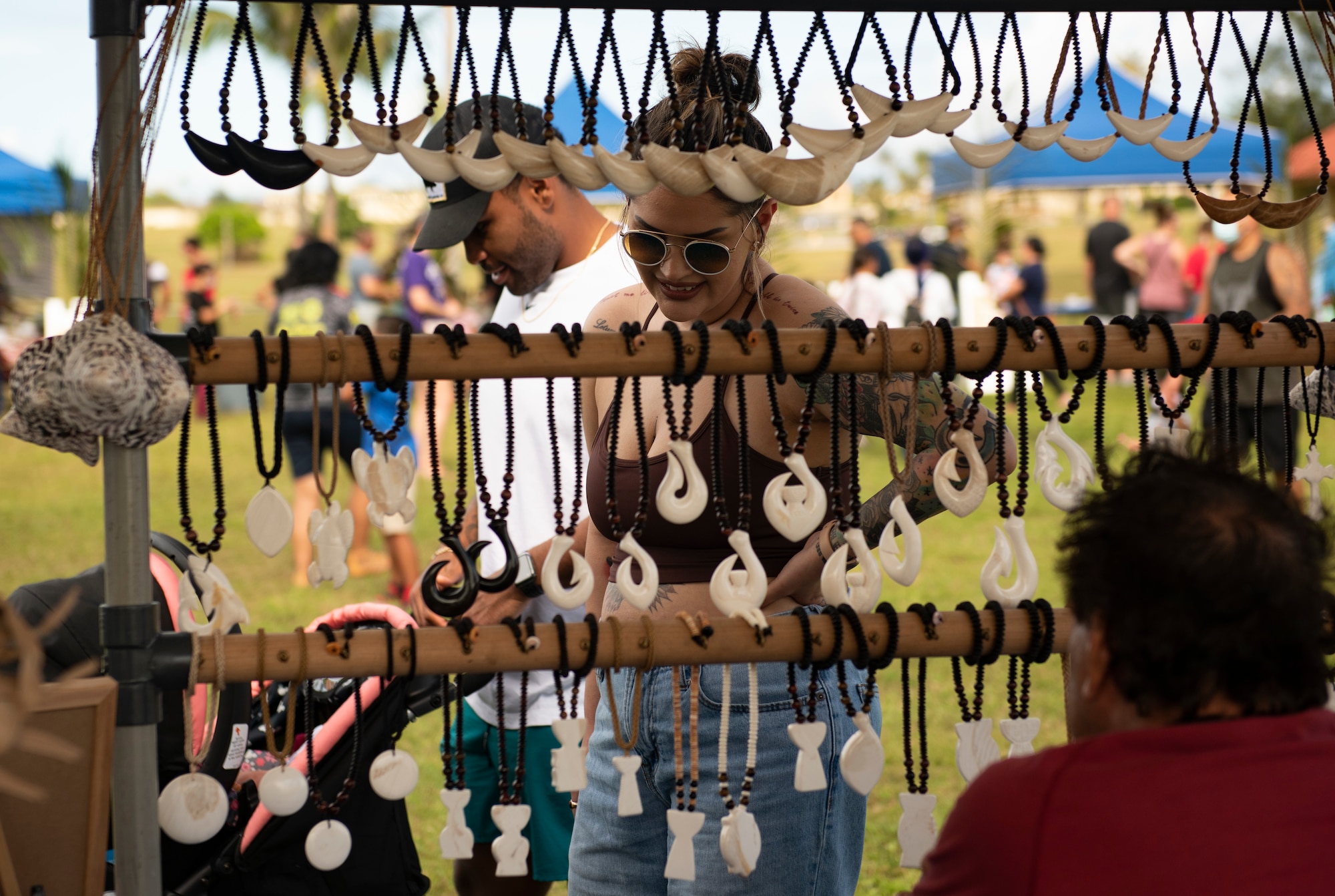 Members from Team Andersen look at locally made jewelry during the annual Tao Tao Guahan event March 12, 2022, at Andersen Air Force Base, Guam. The event focused on immersing Team Andersen members in the local culture of Guam and strengthen the partnerships of the two communities. The event included booths, cultural music and dance, storytelling, food and more. (U.S. Air Force Photo by Senior Airman Helena Owens)