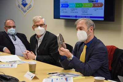 Mr. Chuck Melton inspects an aircraft part created by the additive manufacturing process.