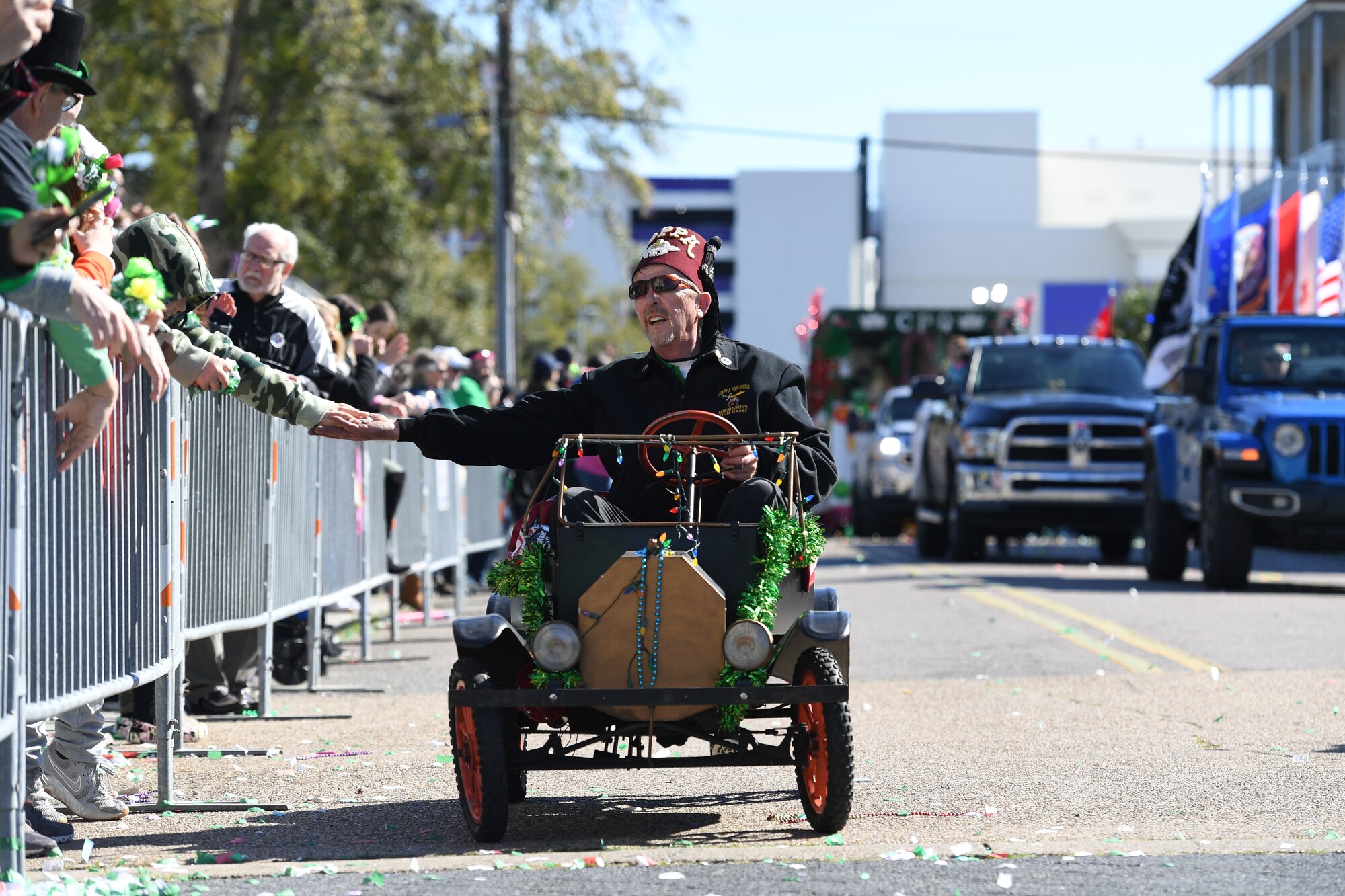 A member of the Joppa Temple Shrine rides through Biloxi during the Hibernia Marching Society of Mississippi St. Patrick's Day Parade in Biloxi, Mississippi, March 12, 2022. Keesler personnel participated in the local parade to show their support of the communities surrounding the installation. (U.S. Air Force photo by Kemberly Groue)