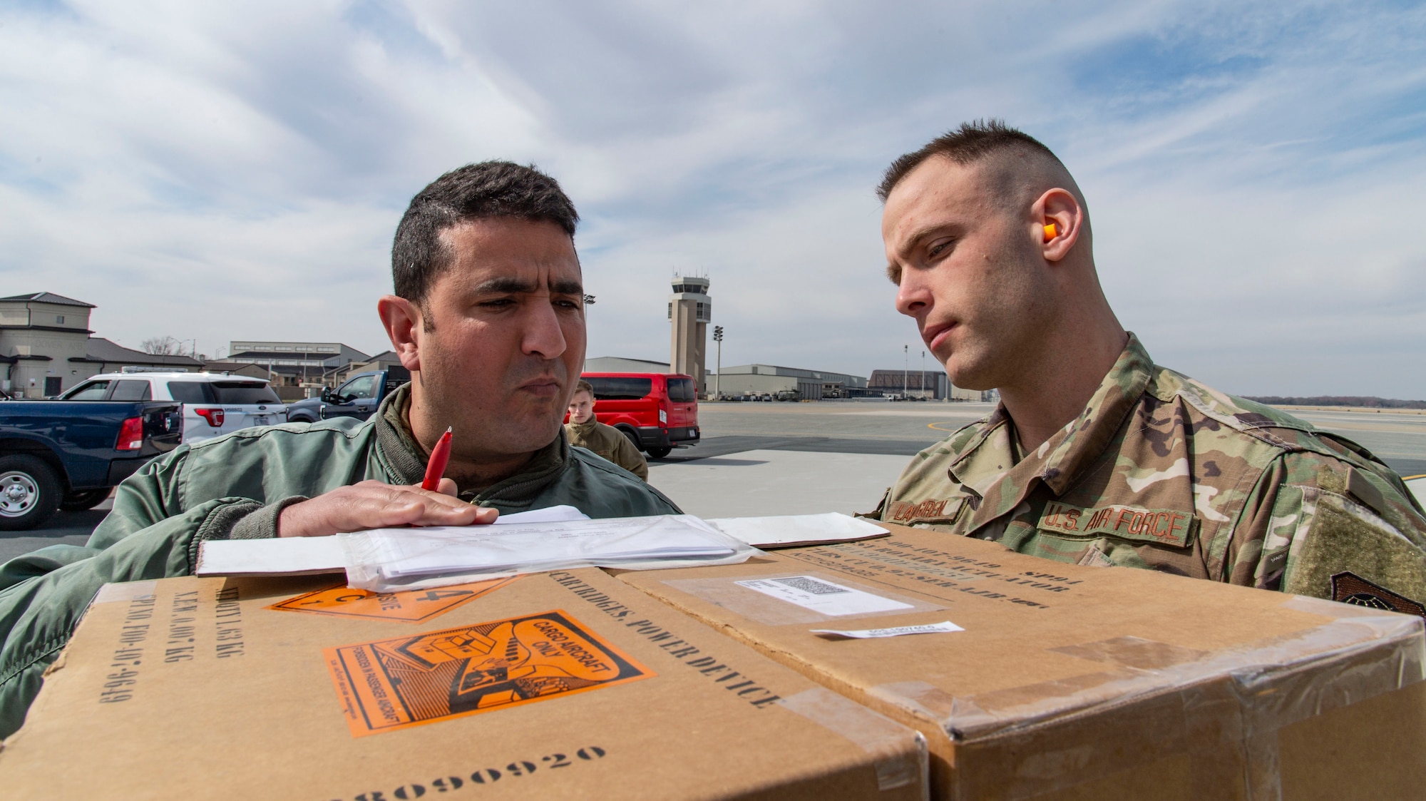 Staff Sgt. Steven Landgren, 436th Aerial Port Squadron special handling supervisor, delivers foreign military sales cargo to a Tunisian air force C-130J Super Hercules aircrew member at Dover Air Force Base, Delaware, March 10, 2022. The U.S. and Tunisia have enjoyed strong diplomatic relations for over 200 years, beginning when the two countries signed the Treaty of Peace and Friendship in 1797. Due to its strategic geographic location, Dover AFB supports approximately $3.5 billion worth of FMS operations annually. (U.S. Air Force photo by Roland Balik)