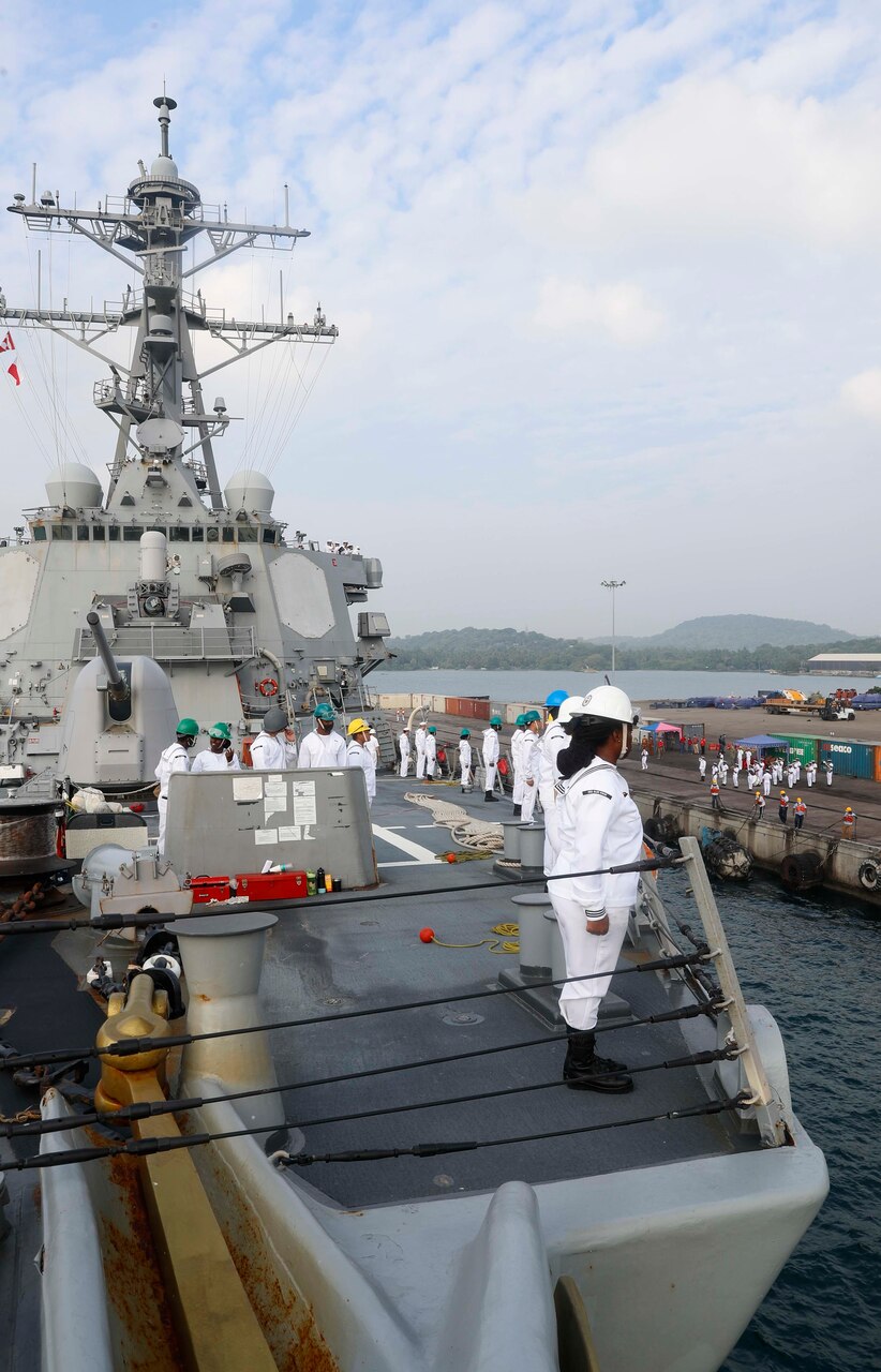 TRINCOMALEE, SRI LANKA (March 13, 2022) Sailors man the rails on the foc’sle of the Arleigh Burke-class guided-missile destroyer USS Fitzgerald (DDG 62) while the Sri Lankan Navy band plays on the pier. Fitzgerald is on a scheduled deployment in the U.S. 7th Fleet area of operations to enhance interoperability with alliances and partnerships while serving as a ready-response force in support of a free and open Indo-Pacific region. (U.S. Navy photo by Mass Communication Specialist 3rd Class Catie Coyle)