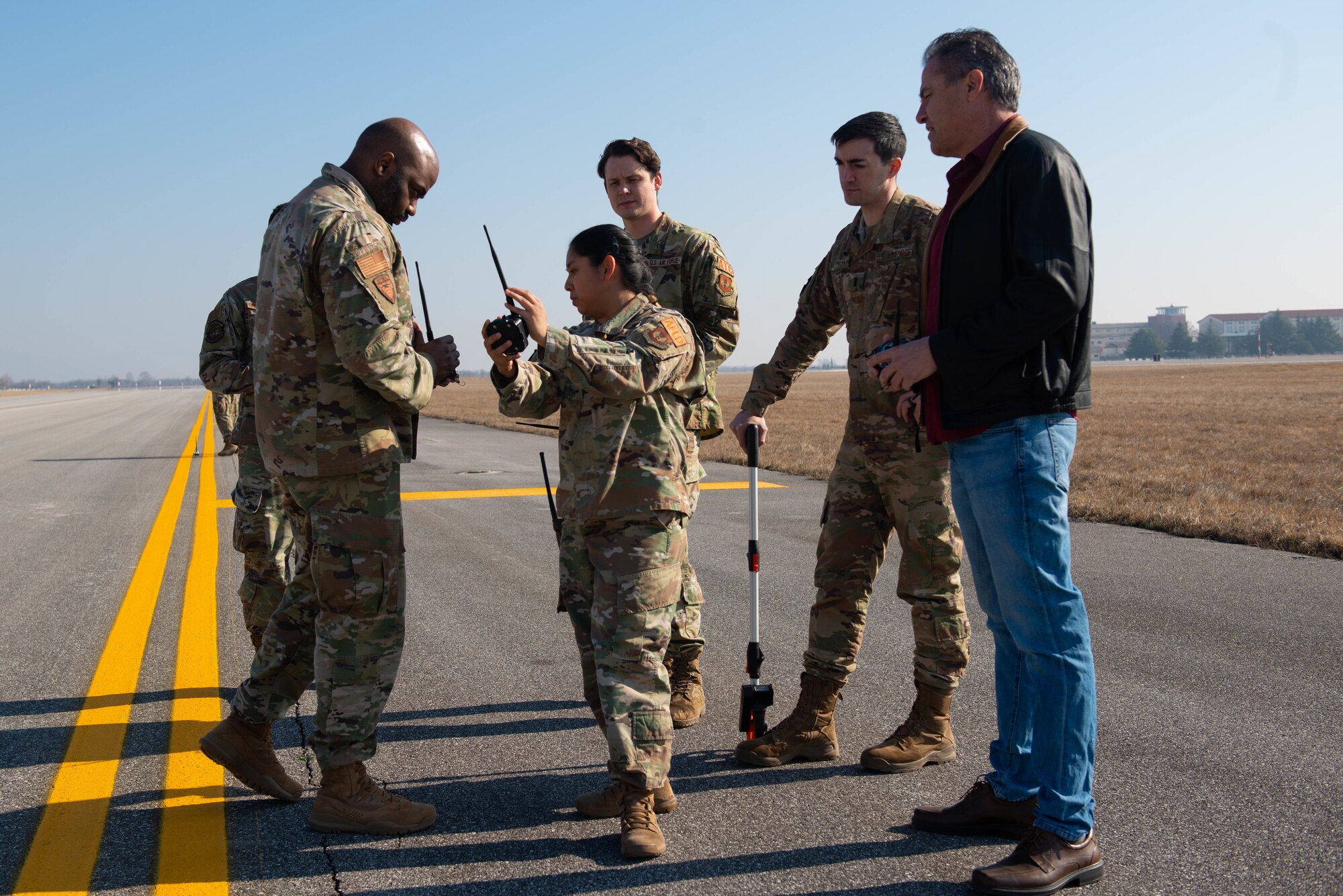 Tech. Sgt. Phonkamon Gehres, 31st Operations Support Squadron Wing airfield driving program manager, explains the usage of a light kit to 31st OSS Airfield Management and Air Traffic Control members at Aviano Air Base, Italy, March 10, 2022. The members trained on airfield management contingency response procedures and used a Phantom AZL-15 lighting kit to simulate  landing zones for different aircraft including, C-17 Globemasters and C-130 Hercules. The Phantom AZL-15 lighting kit contains approximately 35 LED lamps that are powered with batteries and can be turned on anytime or set up with remotes. (U.S. Air Force photo by Airman First Class Calopedis)