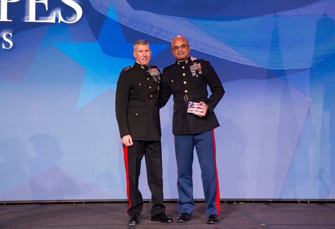 Gen. Eric Smith, Assistant Commandant of the Marine Corps, presents an award to Col. Quintin Jones, the Marine of the Year, at the Stars and Stripes award ceremony at the Omni Shoreham Hotel in Washington D.C., February 18, 2022. Stars and Stripes held their 17th annual award ceremony this year honoring black American service members.