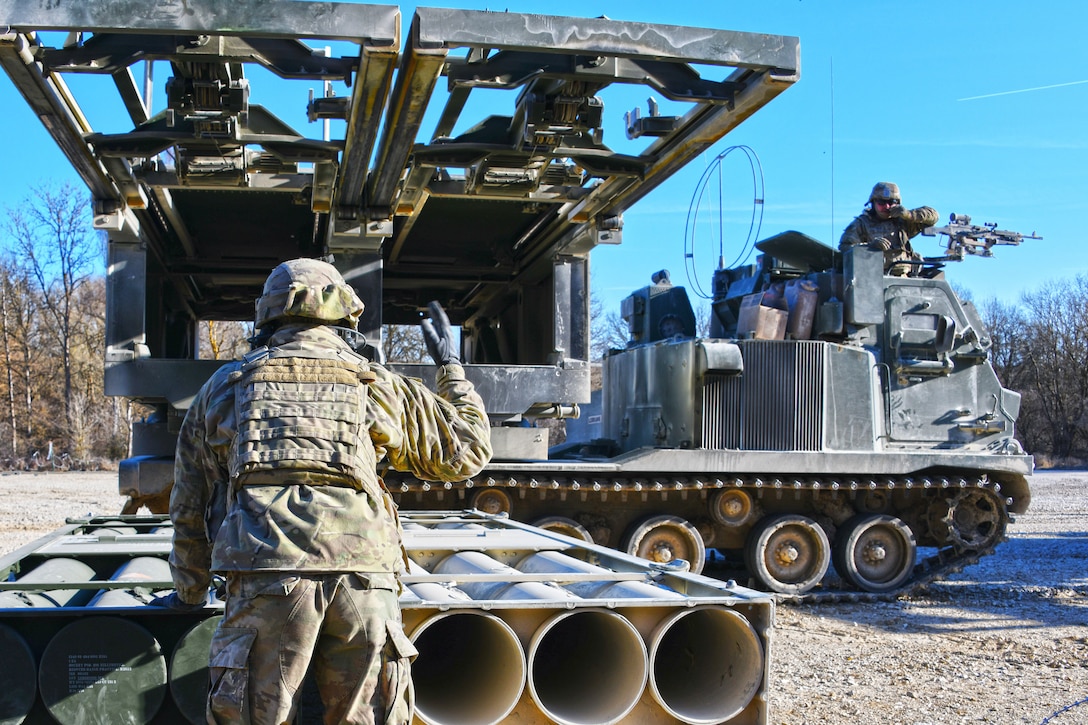 Soldiers load M270 Multiple Launch Rocket Systems for a live fire exercise.