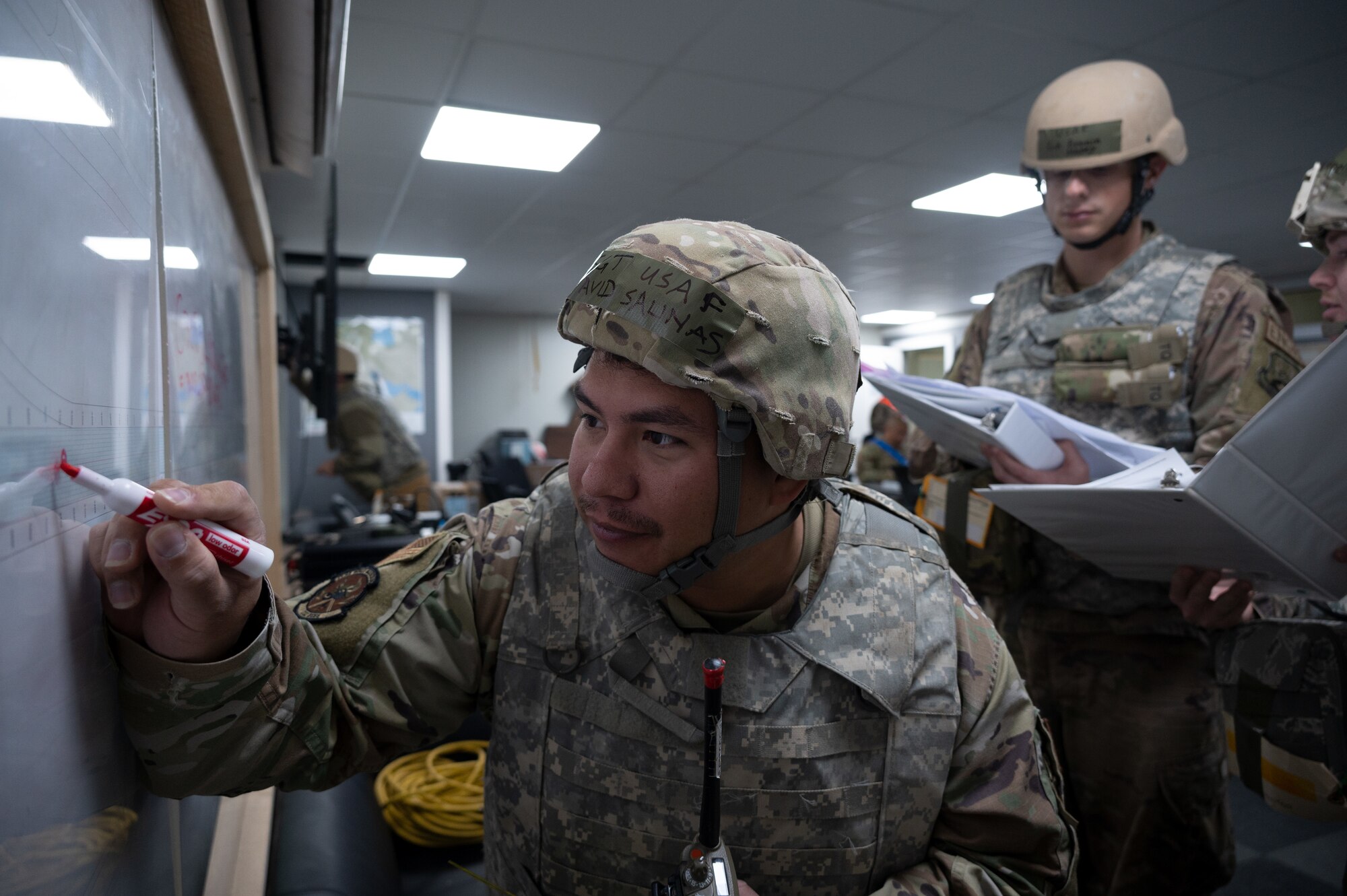 332d Expeditionary Civil Engineer Squadron Airmen plot simulated damages on a map during a Rapid Airfield Damage Recovery (RADR) exercise at an undisclosed location in Southwest Asia, Feb. 10, 2022. This exercise tested the ability of the 332d ECES to rapidly repair runways and runway support structures to recover and resume airfield operations after it has experienced significant damage. The 332d ECES provides, operates, and maintains a sustainable installation through engineering and emergency response services across the full mission spectrum. (U.S Air Force photo by Tech. Sgt. Lauren M. Snyder)