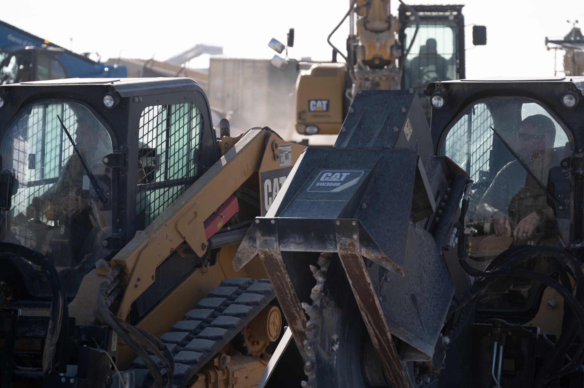 332d Expeditionary Civil Engineer Squadron Airmen wait inside compact track loaders with saw attachments to repair a crater during a Rapid Airfield Damage Recovery (RADR) exercise at an undisclosed location in Southwest Asia, Feb. 10, 2022. This exercise tested the ability of the 332d ECES to rapidly repair runways and runway support structures to recover and resume airfield operations after it has experienced significant damage. The 332d ECES provides, operates, and maintains a sustainable installation through engineering and emergency response services across the full mission spectrum. (U.S Air Force photo by Tech. Sgt. Lauren M. Snyder)