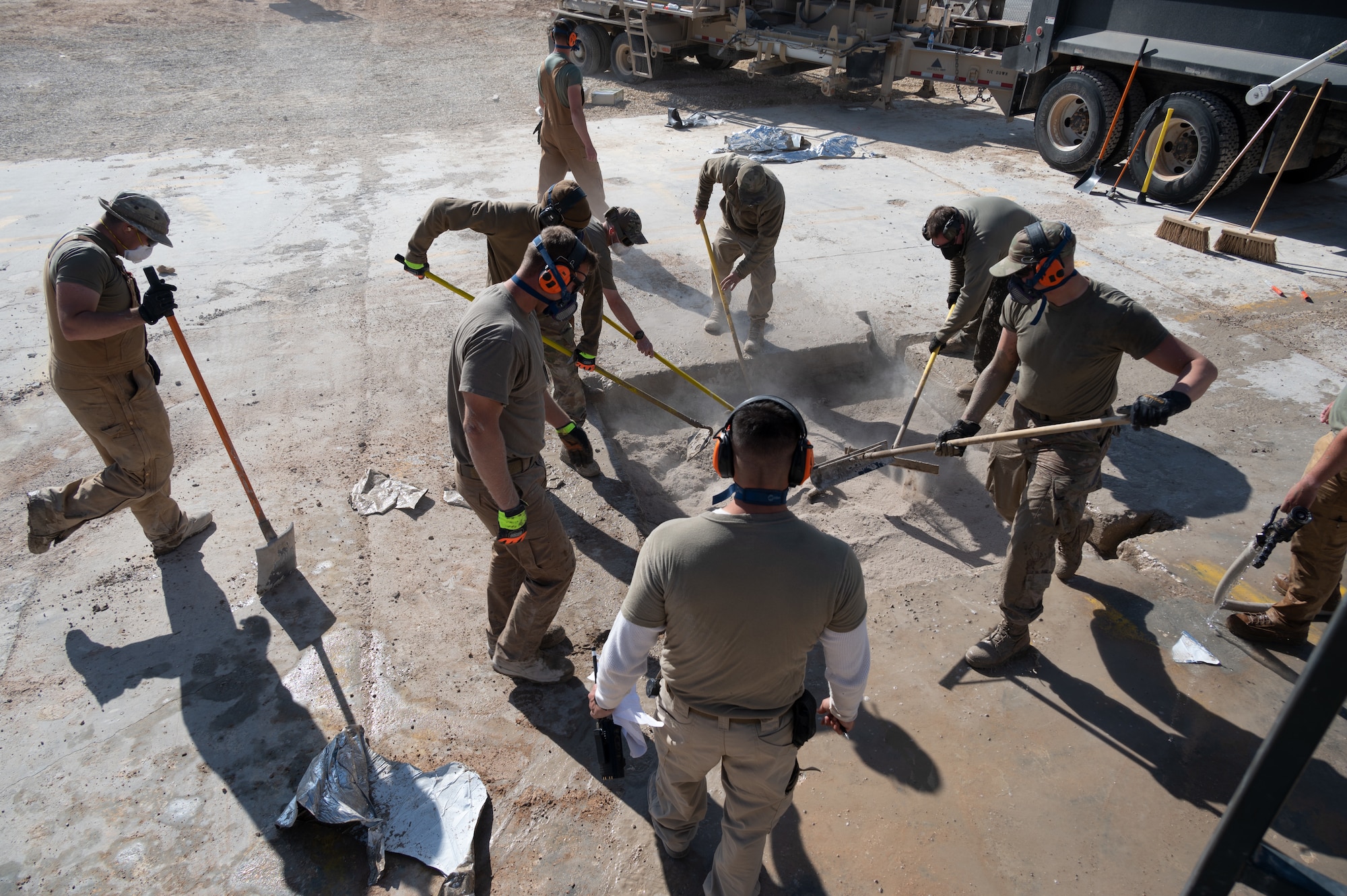 332d Expeditionary Civil Engineer Squadron Airmen work with cement to repair a crater during a Rapid Airfield Damage Recovery (RADR) exercise at an undisclosed location in Southwest Asia, Feb. 10, 2022. This exercise tested the ability of the 332d ECES to rapidly repair runways and runway support structures to recover and resume airfield operations after it has experienced significant damage. The 332d ECES provides, operates, and maintains a sustainable installation through engineering and emergency response services across the full mission spectrum. (U.S Air Force photo by Tech. Sgt. Lauren M. Snyder)