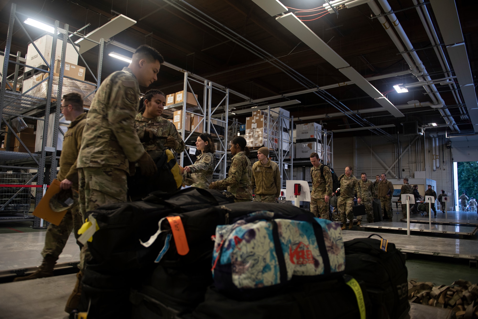 U.S. Air Force Airmen with the 62nd Aerial Port Squadron organize deployers’ personal bags in preparation for Exercise Rainier War 22A at Joint Base Lewis-McChord, Washington, March 15, 2022. Rainier War 22A exercised and evaluated the wing’s ability to employ the force and its  ability to perform during wartime and/or contingency taskings in a high-intensity, wartime contested, degraded and operationally limited environment while supporting the contingency operations against a near-peer adversary. (U.S. Air Force photo by Master Sgt. Julius Delos Reyes)