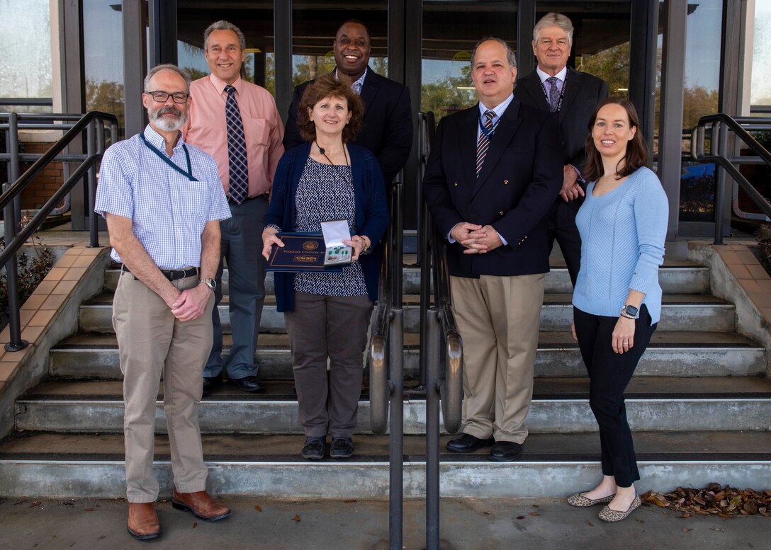 (left to right) Rudy Arrieta, Dr. Joe Lopes, Lisa Arrieta, Dr. Jermaine Kennedy, Dr. Keith Aliberti, Randy Lee, Amanda Bobe stand together after Lisa Arrieta received a Department of the Navy Civilian Service Commendation medal during a ceremony held here on Feb. 23. Arrieta serves as the Acoustic Test Facility manager/Service Cost Center lead. Since 2009, her efforts have been significant in obtaining $74M Capital Improvement Projects and Military Construction funding dollars for NSWC PCD projects. This funding will provide facilities to further technology and advance the development of systems to ultimately benefit the warfighter. ​(U.S. Navy photo by Eddie Green)