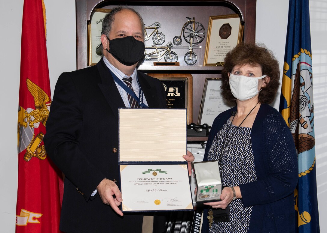 (left) Dr. Keith Aliberti, SSTM, NWSC PCD X Department head presents Lisa Arrieta NWSC PCD Acoustic Test Facility manager/Service Cost Center lead with a Department of the Navy Civilian Service Commendation medal on February 23. Since 2009, her efforts have been significant in obtaining $74M Capital Improvement Projects and Military Construction funding dollars for NSWC PCD projects which will ultimately help to provide solutions to the warfighter. (U.S. Navy photo by Eddie Green)