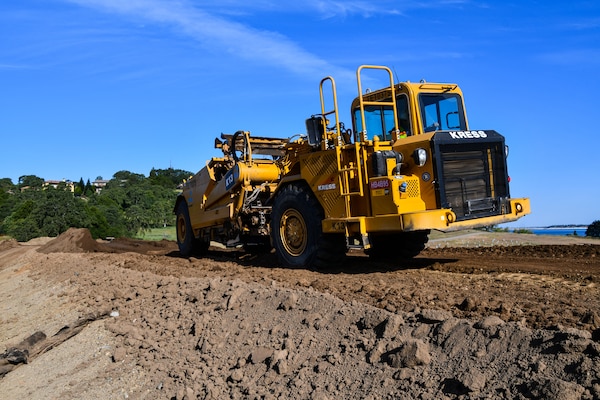 Heavy equipment on a dike overlooking a lake