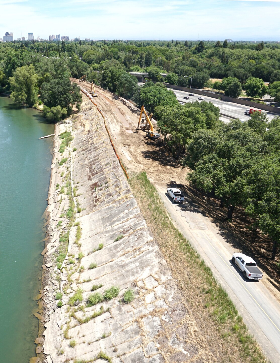 A levee along a river with a city in the background
