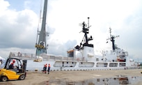 A Georgian forklift driver drives toward a pallet of humanitarian assistance supplies being crane lifted from the U.S. Coast Guard Cutter Dallas.