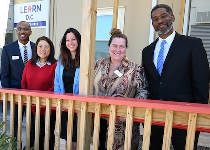 Alonso Hay, Joint Base Anacostia-Bolling school liaison (left); Cherise Imai, executive director of the Military Interstate Children's Compact Commission (center left); Commissioner Clara Botstein, director of legislation and government relations at the D.C. office of the deputy mayor for education (center); Teresa Quinn-Veseley, 11th Force Support Squadron; and Horace Franklin; Naval District Washington school liaison, pose for a group photo on March 15, 2022 on the campus of the first charter school on JBAB, Washington, D.C. Botstein and Imai toured JBAB, Washington, D.C. and met members of the 11th Force Support Squadron in order to gain a deeper understanding of LEARN DC and the concerted interagency effort that made it possible, as well as to learn about the diverse mission partners that operate on the installation. (U.S. Air Force photo by Staff Sgt. Kayla White)