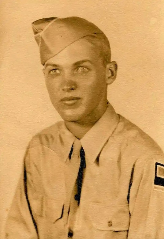 A young man poses for a photo while wearing a crooked cap.