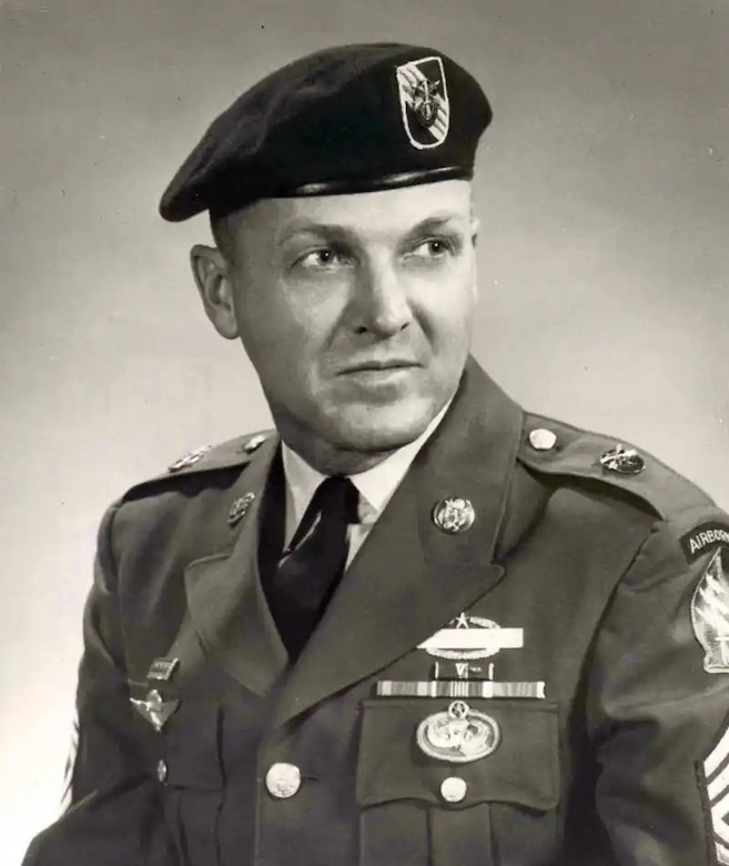 A man in service dress uniform and beret poses for a photo.