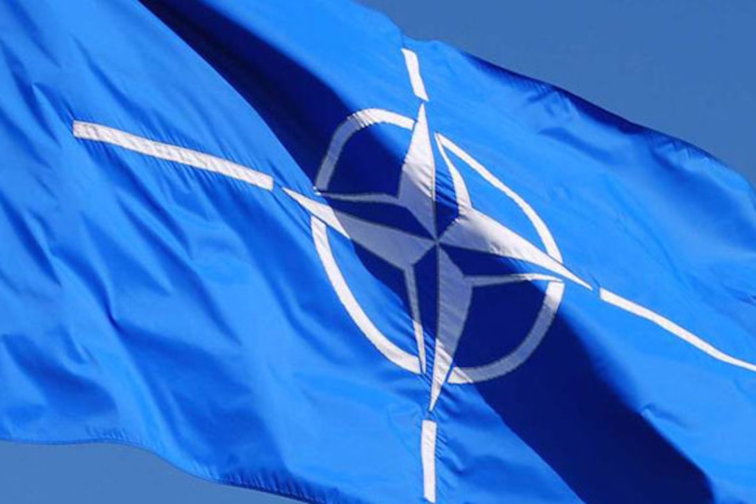 Blue flag with NATO emblem waves