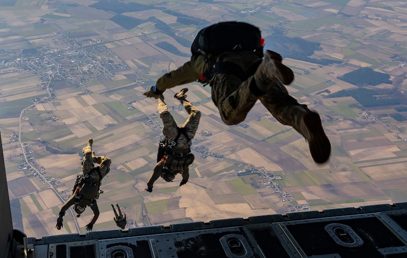 Troops jump out of an airplane.