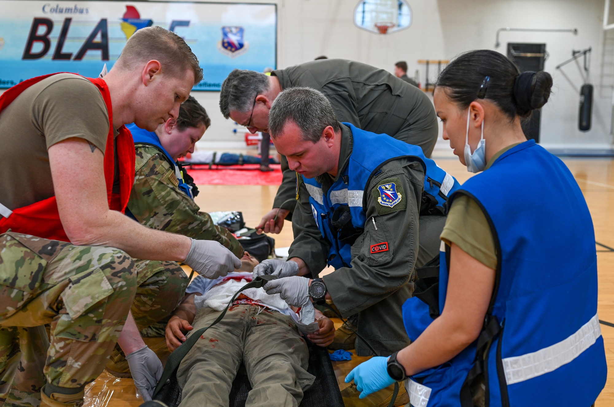 Five medics from the 14th Medical Group at Columbus Air Force Base, Miss., perform first responder actions at the Ready Eagle Exercise on March 11, 2022. The Ready Eagle Training focuses on emergency medical treatment, tactical combat casualty care, patient decontamination, patient tracking, resource tracking and bioenvironmental training. (U.S. Air Force photo by Senior Airman Davis Donaldson)