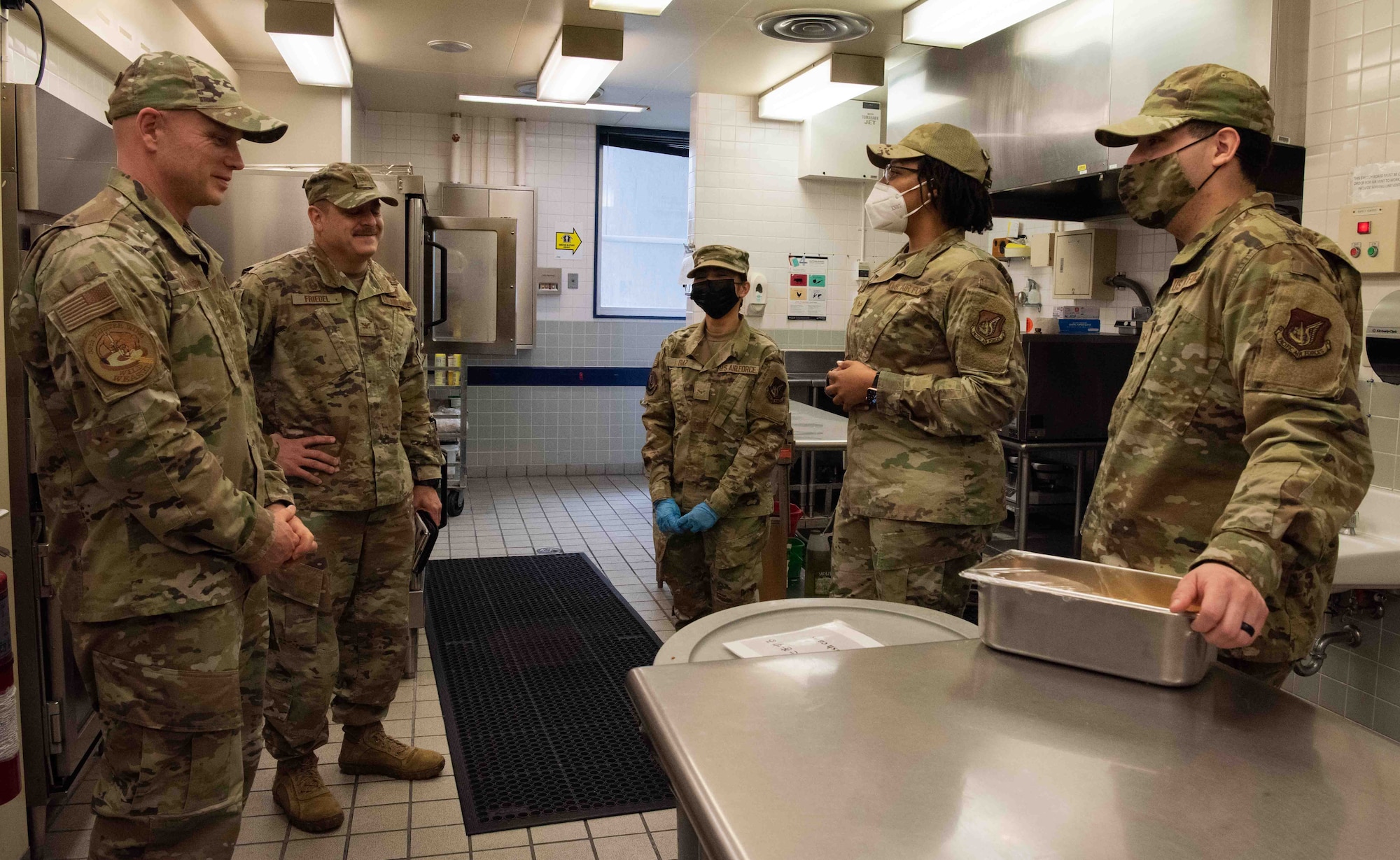 Military members talk to each other in the Falcon Feeder kitchen