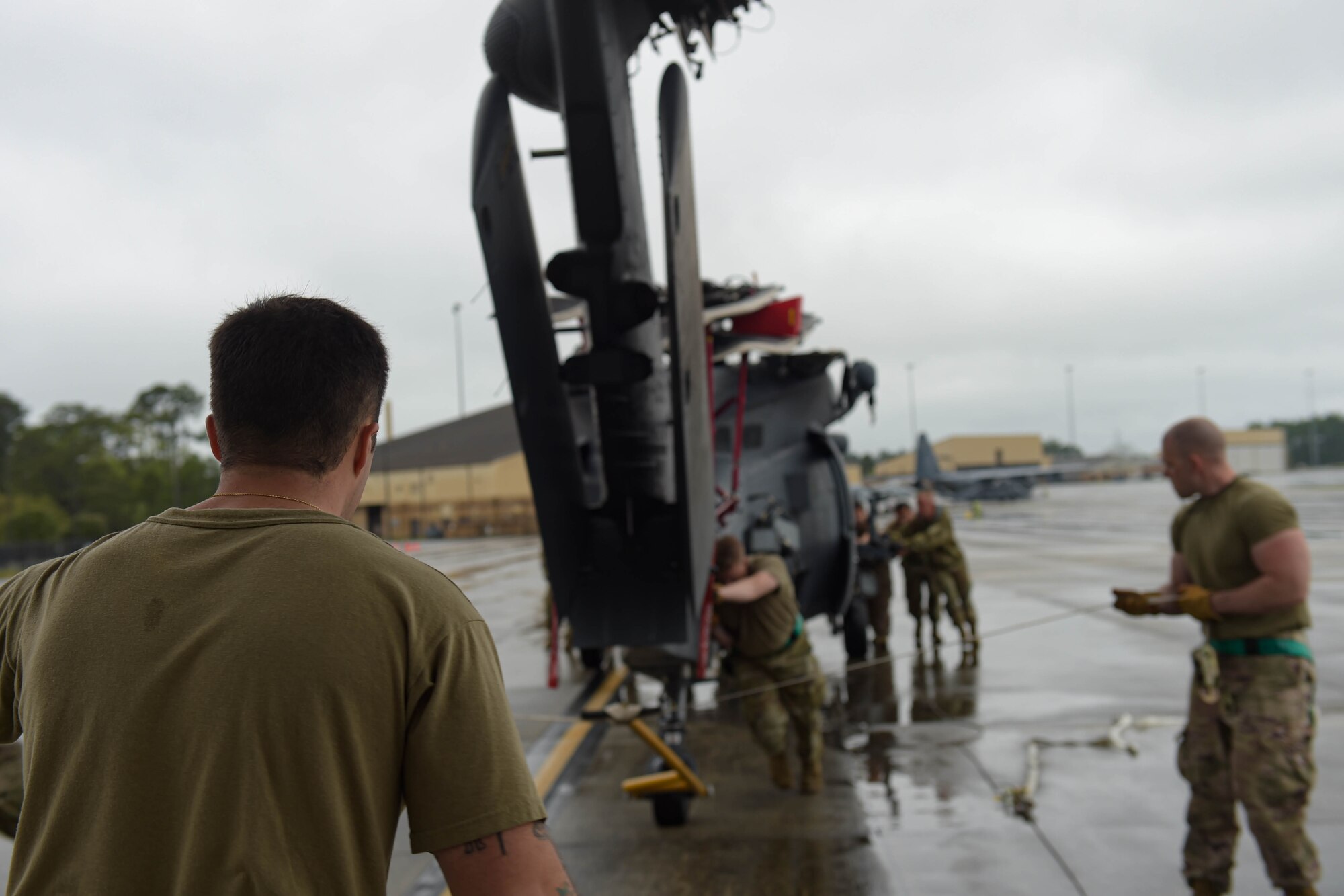 A photo of Airmen pushing a helicopter.