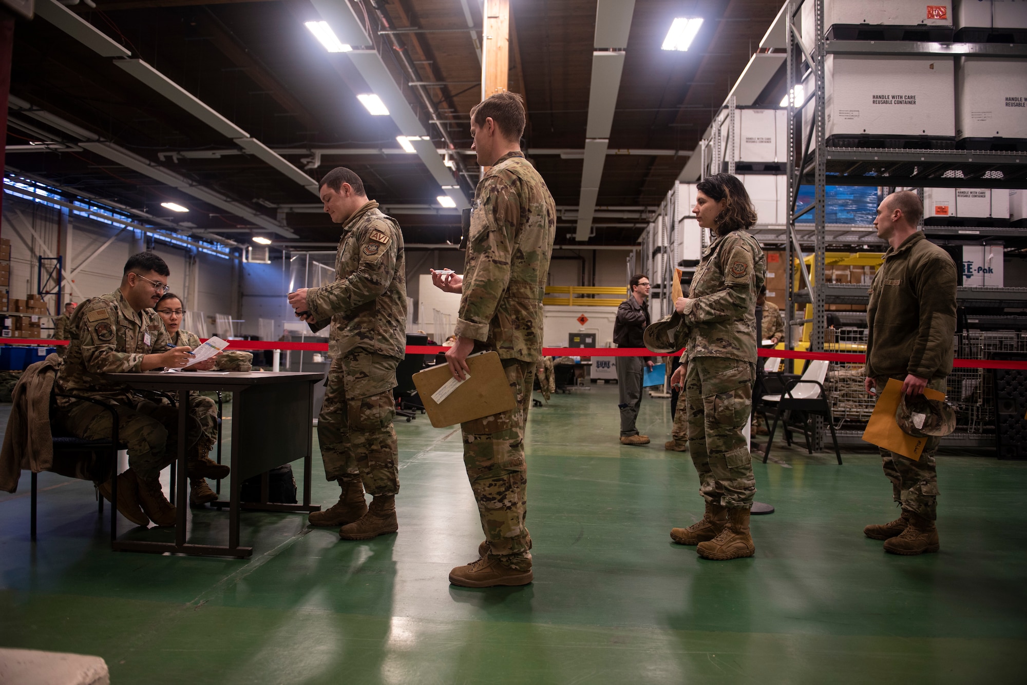 U.S. Air Force Airmen check in with Installation Personnel Readiness for the deployment line as part of Exercise Rainier War 22A at Joint Base Lewis-McChord, Washington, March 15, 2022. Rainier War 22A exercised and evaluated the wing’s ability to employ the force and its  ability to perform during wartime and/or contingency taskings in a high-intensity, wartime contested, degraded and operationally limited environment while supporting the contingency operations against a near-peer adversary. (U.S. Air Force photo by Master Sgt. Julius Delos Reyes)