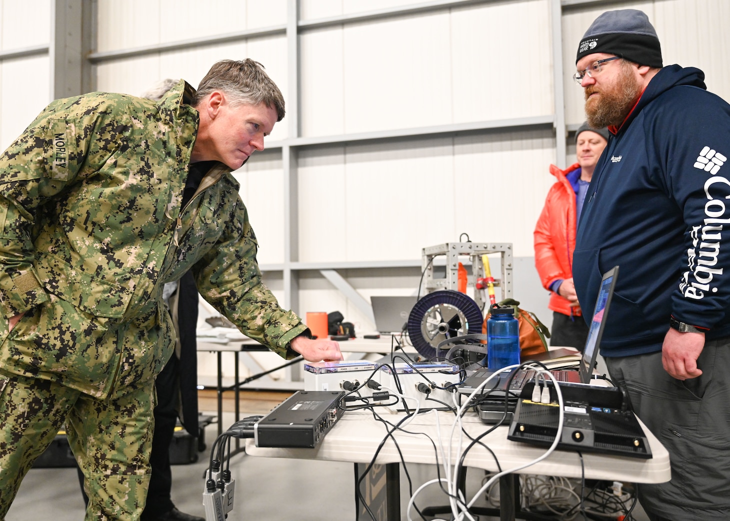 Vice Adm. Frank Morley, left, Principal Military Deputy Assistant Secretary of the Navy for Research, Development and Acquisition, tests a seismometer while Benjamin Evans, a researcher from the Massachusetts Institute of Technology (MIT) Lincoln Laboratory Advanced Undersea Systems and Technology Group, explains his team's research at the Deadhorse Aviation Center-East hangar in Prudhoe Bay, Alaska, during Ice Exercise (ICEX) 2022.