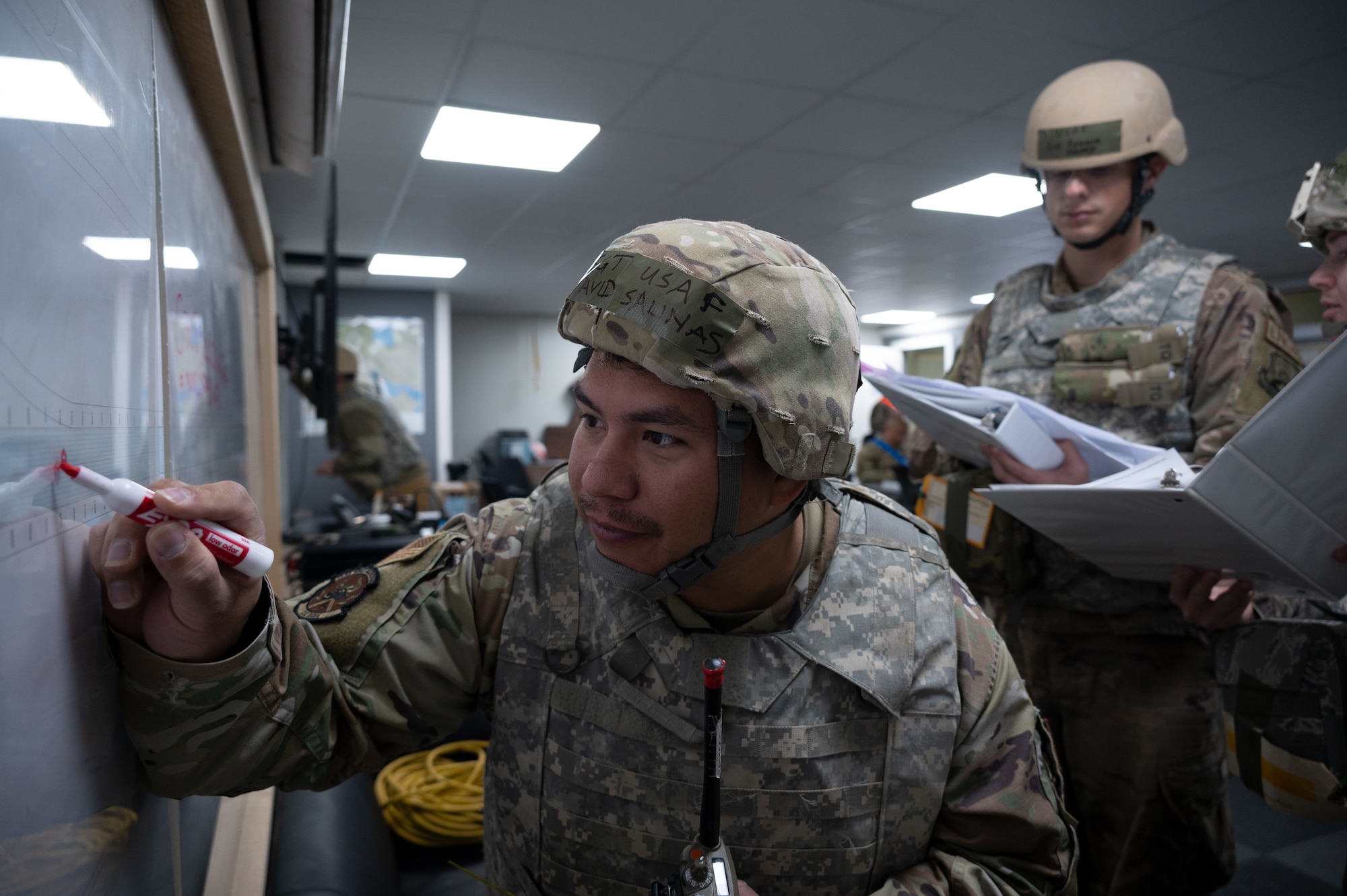 332d Expeditionary Civil Engineer Squadron Airmen plot simulated damages on a map during a Rapid Airfield Damage Recovery (RADR) exercise at an undisclosed location in Southwest Asia, Feb. 10, 2022. This exercise tested the ability of the 332d ECES to rapidly repair runways and runway support structures to recover and resume airfield operations after it has experienced significant damage. The 332d ECES provides, operates, and maintains a sustainable installation through engineering and emergency response services across the full mission spectrum. (U.S Air Force photo by Tech. Sgt. Lauren M. Snyder)