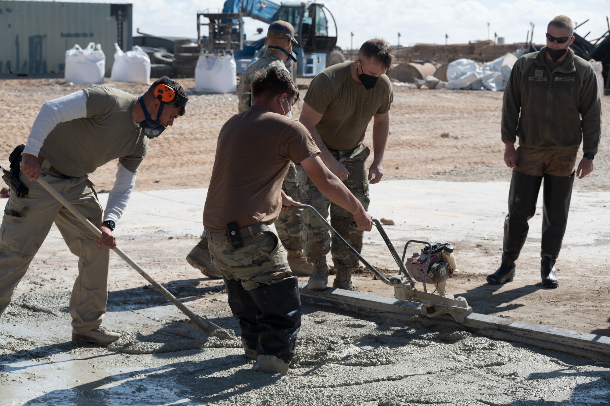 332d Expeditionary Civil Engineer Squadron Airmen work with cement to repair a crater during a Rapid Airfield Damage Recovery (RADR) exercise at an undisclosed location in Southwest Asia, Feb. 10, 2022. This exercise tested the ability of the 332d ECES to rapidly repair runways and runway support structures to recover and resume airfield operations after it has experienced significant damage. The 332d ECES provides, operates, and maintains a sustainable installation through engineering and emergency response services across the full mission spectrum. (U.S Air Force photo by Tech. Sgt. Lauren M. Snyder)