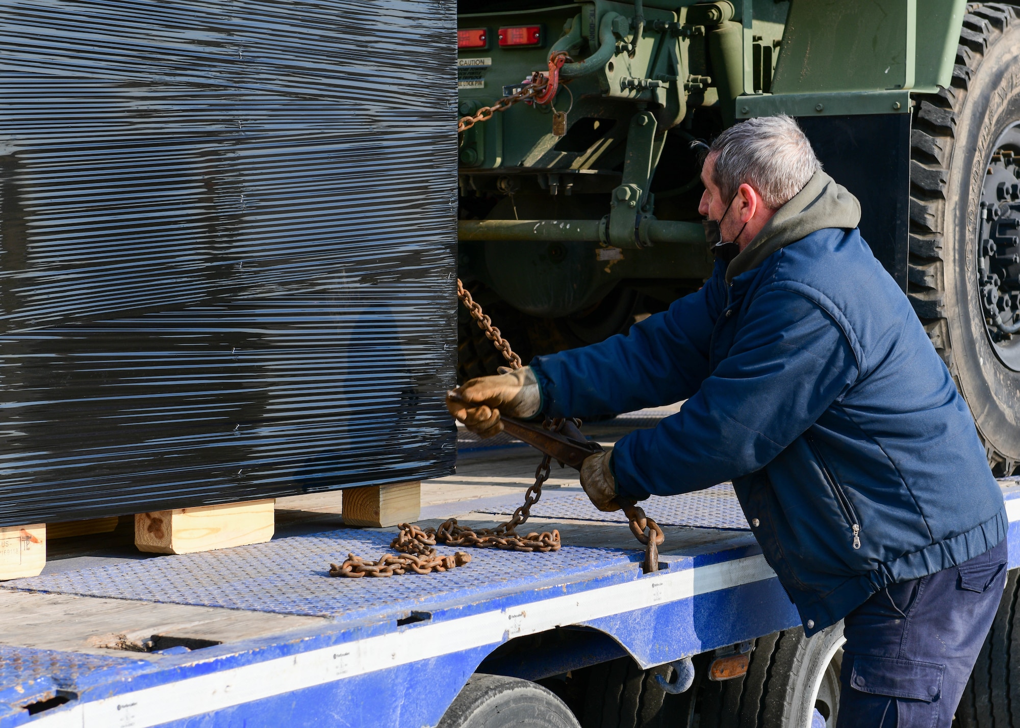 An off-base contracted employee secures a cargo pallet onto a trailer at Aviano Air Base, Italy, March 4, 2022. The 31st Logistics Readiness Squadron Traffic Management section sent cargo such as trucks, medical supplies, computer equipment, mobility bags and more to deployed members in Eastern Europe. (U.S. Air Force photo by Senior Airman Brooke Moeder)