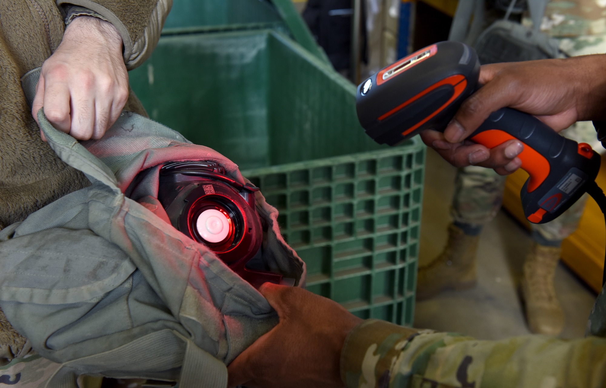 U.S. Air Force Airman 1st Class Demetrius Bates, right, 100th Logistics Readiness Squadron Individual Protective Equipment apprentice, scans in old, used gas masks before they are packed and returned to depot in the States at Royal Air Force Mildenhall, England, March 15, 2022. Airmen in the IPE shop support geographically separated units including RAF Croughton, and Stavanger, Norway, and issue all gear for chemical warfare assets to members tasked for deployments and TDYs, ensuring they are issued the correct equipment. (U.S. Air Force photo by Karen Abeyasekere)