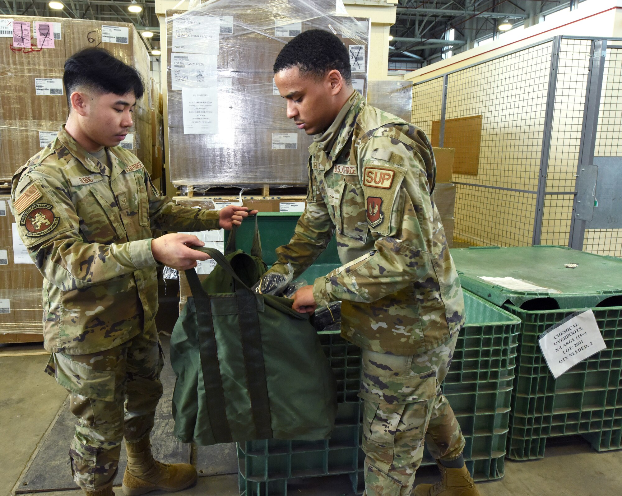 U.S. Air Force Airman 1st Class Kendrew Olboc, left, and Airman Yomar Celeste, both 100th Logistics Readiness Squadron Individual Protective Equipment apprentices, pack a real-world chemical “Class C” bag at Royal Air Force Mildenhall, England, March 15, 2022. Airmen in the IPE shop support geographically separated units including RAF Croughton, and Stavanger, Norway, and issue all gear for chemical warfare assets to members tasked for deployments and TDYs, ensuring they are issued the correct equipment. (U.S. Air Force photo by Karen Abeyasekere)