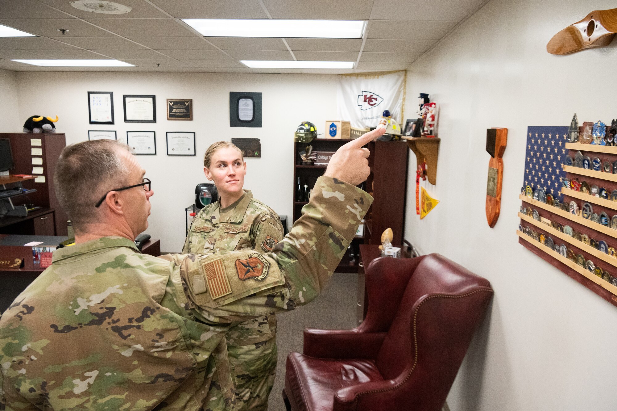 Chief Master Sgt. Timothy Bayes, left, 436th Airlift Wing command chief, discusses office mementoes with Airman 1st Class Shayna Teunissen, 436th Comptroller Squadron budget analyst, at Dover Air Force Base, Delaware, March 16, 2022. Teunissen accompanied Bayes as part of the Chief for the Day mentoring program, which offers Airmen a first-hand experience of the command chief’s typical work day. (U.S. Air Force photo by Mauricio Campino)