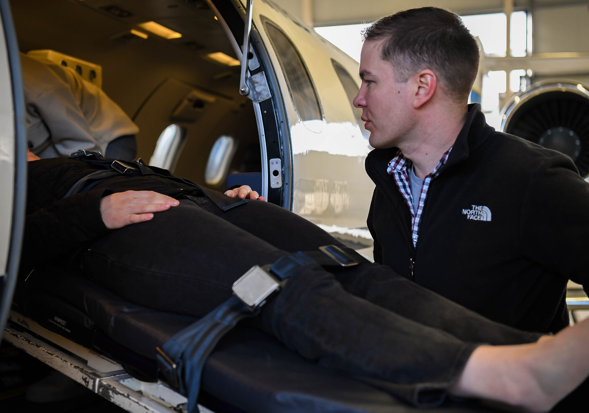 U.S. Air Force Capt. Adam Olligschlager, 86th Airlift Wing plans and programs action officer, loads a simulated litter patient onto a C-21 aircraft for aeromedical evacuation training at Ramstein Air Base, Germany, March 11, 2022. Olligschlager performs training exercises such as this to keep up his skills and ensure that all nurses remember mission and clinical requirements for transferring patients via aircraft. When Olligschlager isn’t working as an action officer, he assumes regular duties as a flight nurse evaluator at the 86th Aeromedical Evacuation Squadron. (U.S. Air Force photo by Airman 1st Class Jared Lovett)