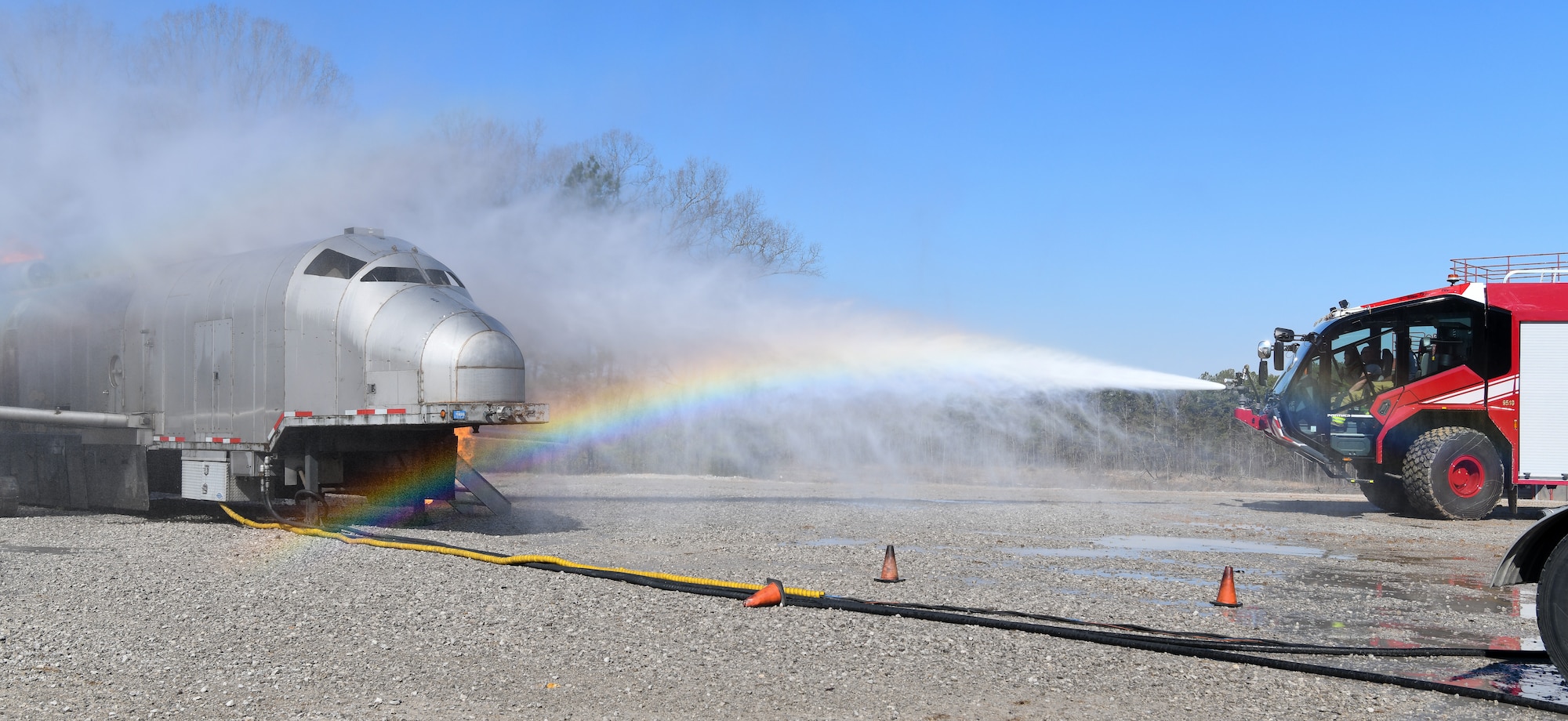 Spray from firefighting vehicle bumper turret creating a rainbow