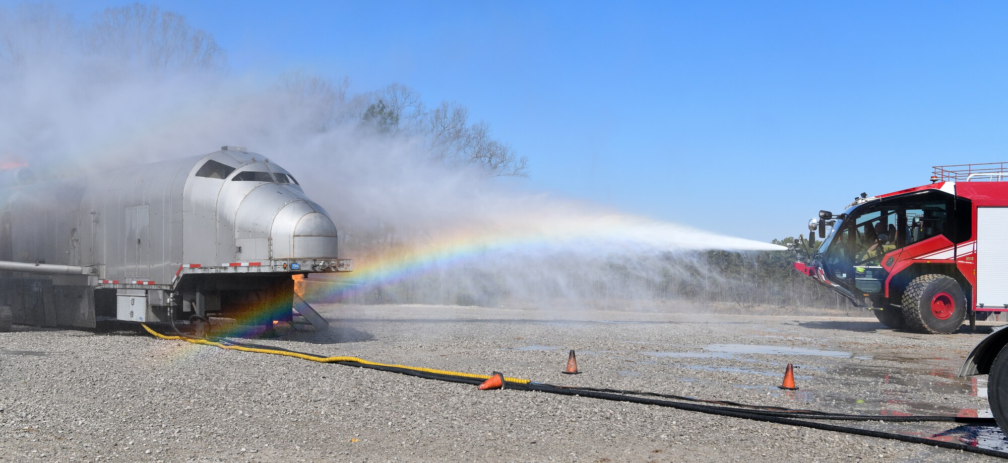 Spray from firefighting vehicle bumper turret creating a rainbow