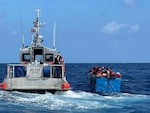 A 45-foot response boat from Station Key West, Fla., is alongside a rustic vessel approximately 15 miles south of Key West, March 9, 2022. Customs and Border Protection Air and Marine Operations flight crew reported the rustic vessel with people aboard to U.S. Coast Guard Sector Key West watchstanders. U.S. Coast Guard Cutter Kathleen Moore’s crew repatriated 74 people to Cuba, March 12, 2022, following four interdictions of undocumented migrants due to safety of life at sea concerns. (U.S. Coast Guard photo)