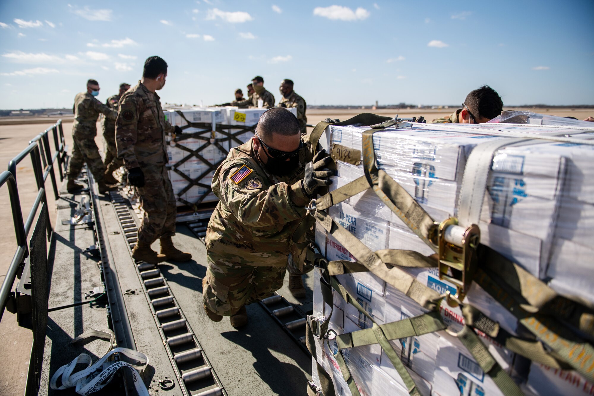 U.S. Air Force Airmen and Army Soldiers unload pallets of bottled water, Feb. 21, 2021, at Joint Base San Antonio-Kelly Field, Texas.