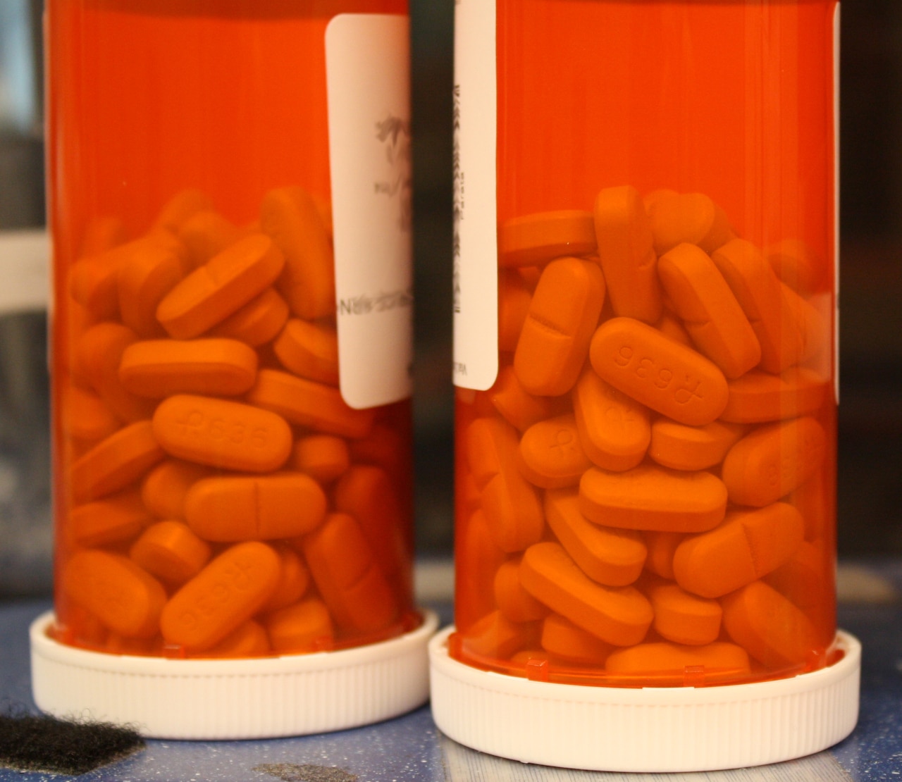 Two bottles of pills sit on a counter.