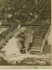 A aerial view of the USS LAFAYETTE (ex- SS NORMANDIE) burning in New York City while the passenger liner was undergoing conversion to a troopship.