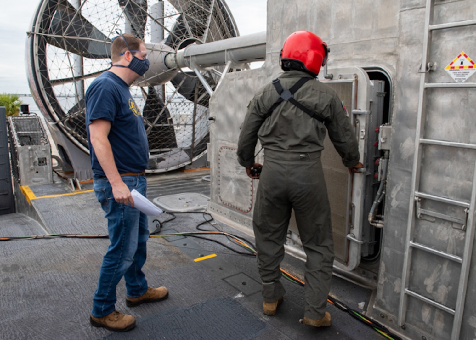Ben Ridenour (left), an engineer in Carderock’s Vulnerability Assessment Branch, observes as BM2 Michael Tige (right) begins to troubleshoot the LCAC 100 after it has received damage in the controlled damage test.