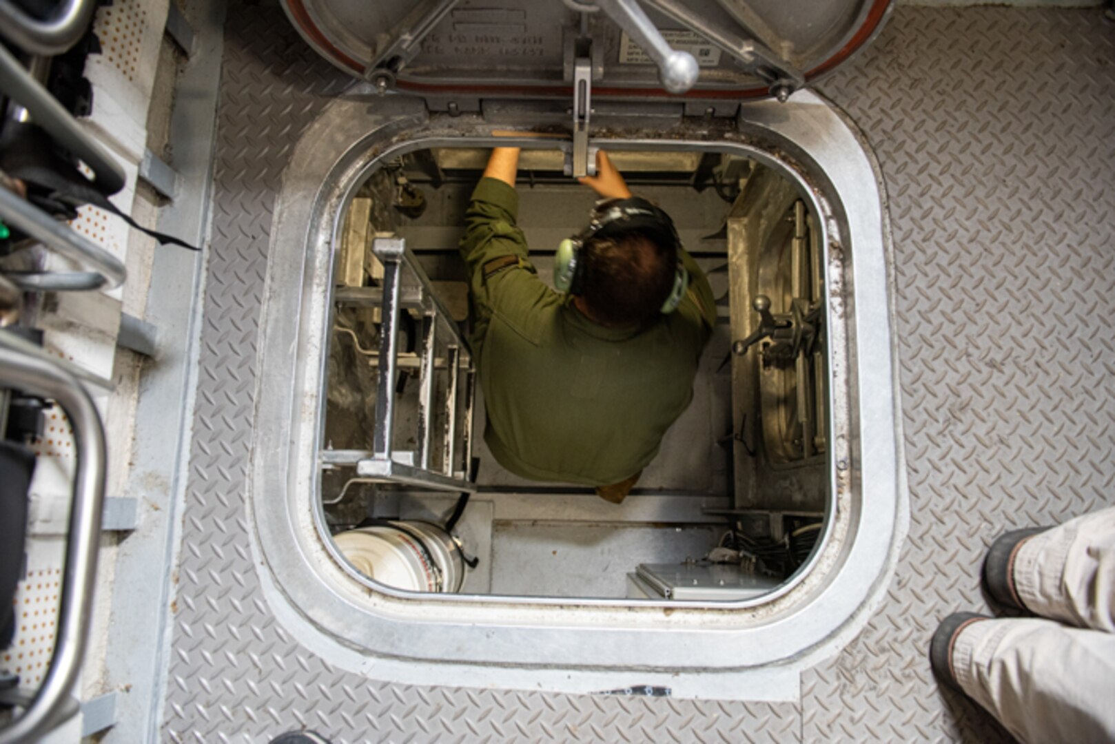 AE1 Dylan Glemming (Flight Engineer) goes below deck during a scenario for the controlled damage tests on the LCAC 100.