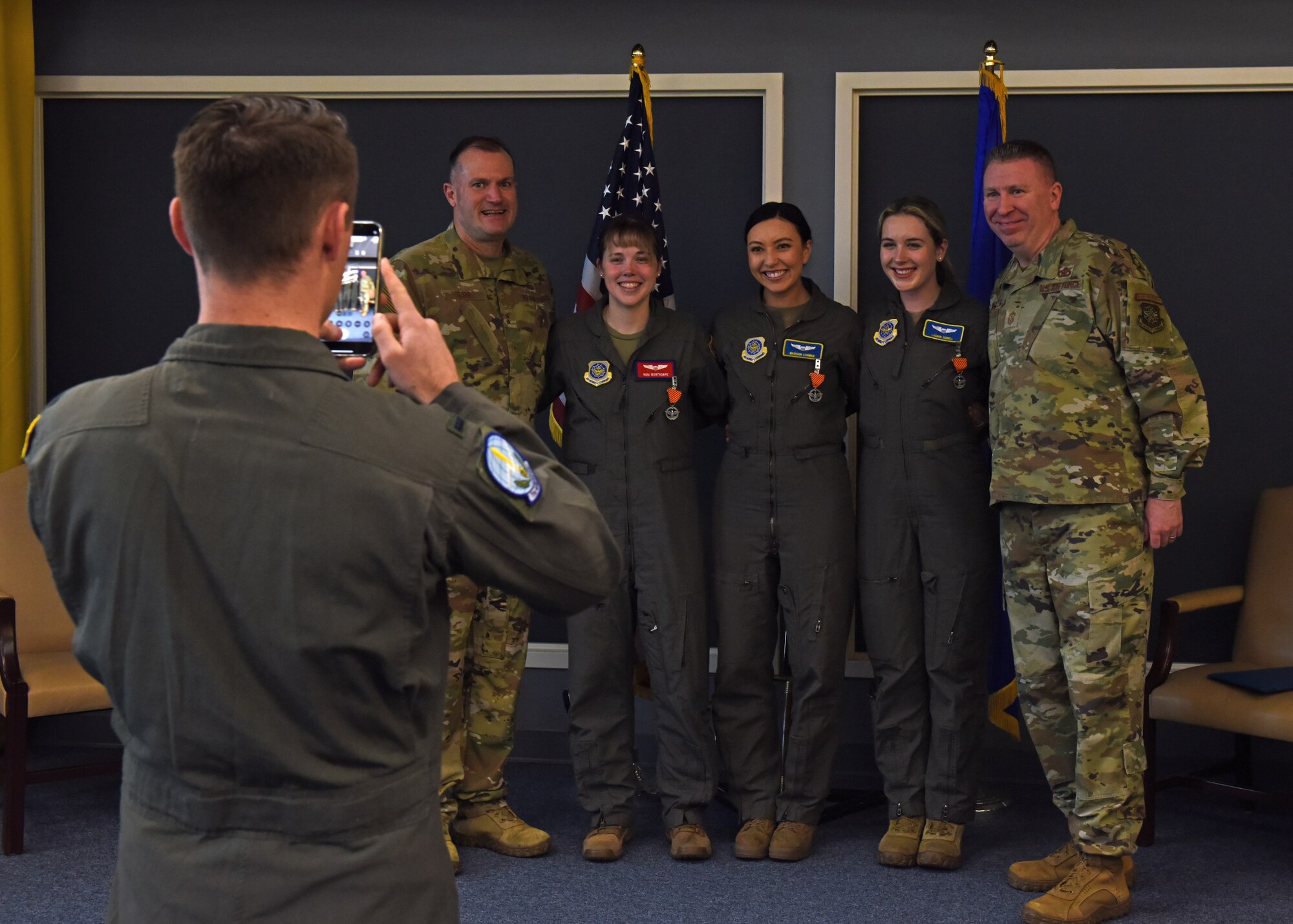 U.S. Air Force Maj. Gen. Thad Bibb, 18th Air Force commander, and U.S. Air Force Chief Master Sgt. Chad Bickley, 18th AF command chief, pose for a photo after presenting Air Force Combat Action Medals to three 62nd Airlift Wing pilots at Joint Base Lewis-McChord, Washington, March 14, 2022. U.S. Air Force Capt. Roni Morthorpe, 1st Lt. Madison Lohman and 1st Lt. Lauren Norell received medals for their honorable service during Operation Allies Refuge in August 2021. (U.S. Air Force photo/Senior Airman Zoe Thacker)