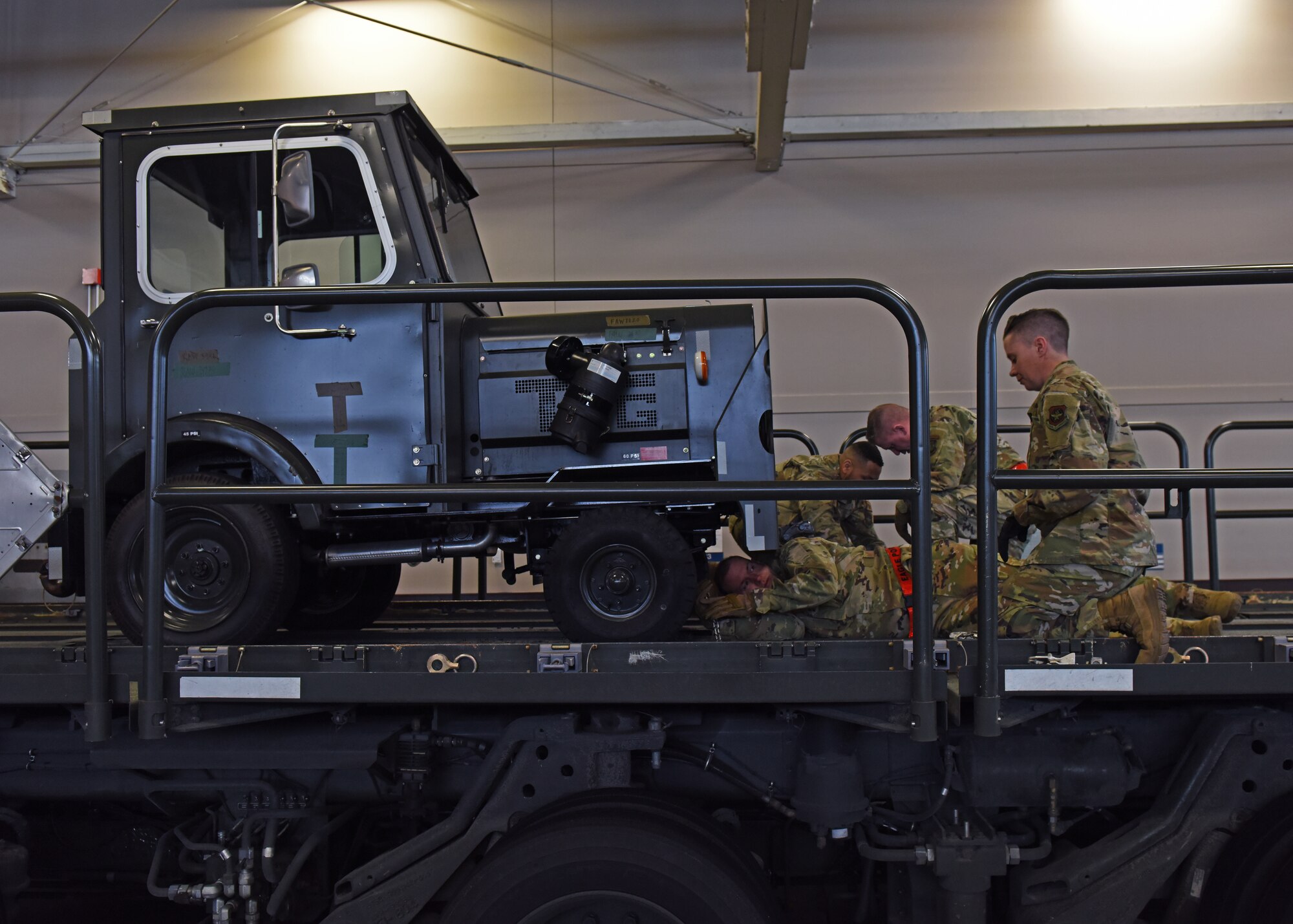 U.S. Air Force Maj. Gen. Thad Bibb, 18th Air Force commander, and U.S. Air Force Chief Master Sgt. Chad Bickley, 18th AF command chief, upload a vehicle with 62nd  Aerial Port Squadron Airmen at Joint Base Lewis-McChord, Washington, March, 15, 2022. Bibb and Bickley competed with the 62nd APS Port Dawgs to see which team could upload a vehicle faster after recognizing some of the squadron’s top performers. (U.S. Air Force photo/Senior Airman Zoe Thacker)